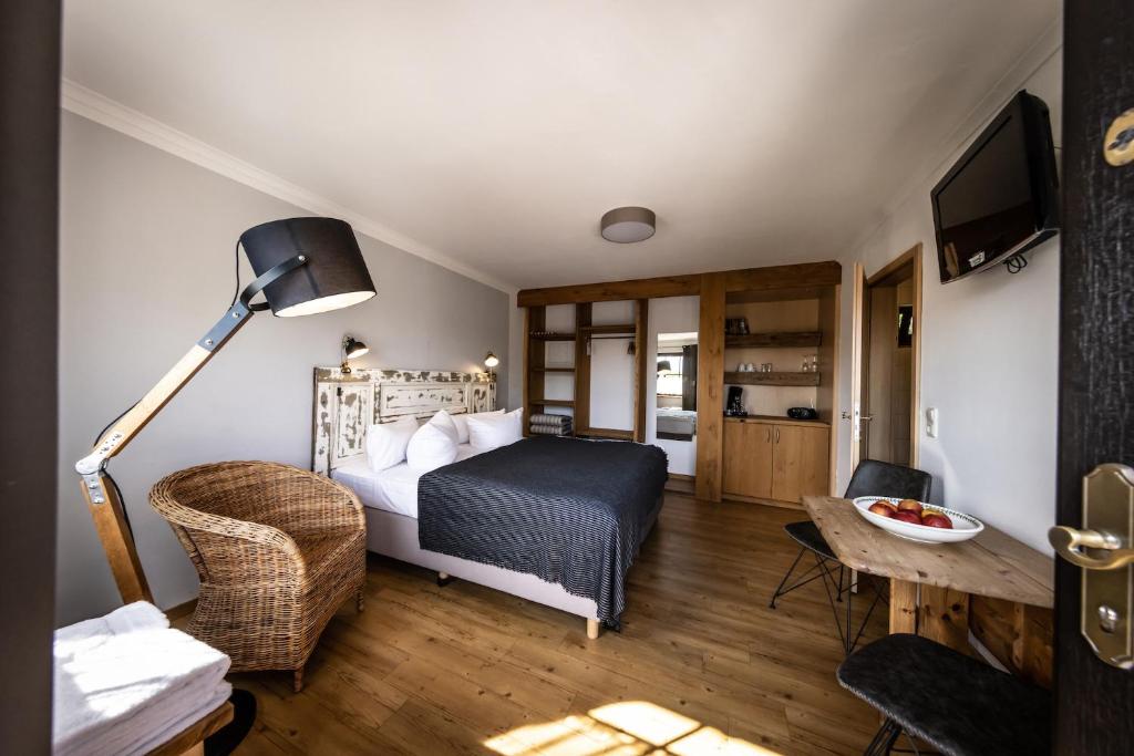a bedroom with a bed and a chair and a table at Superior Doppelzimmer 1-2 Personen in Bastorf
