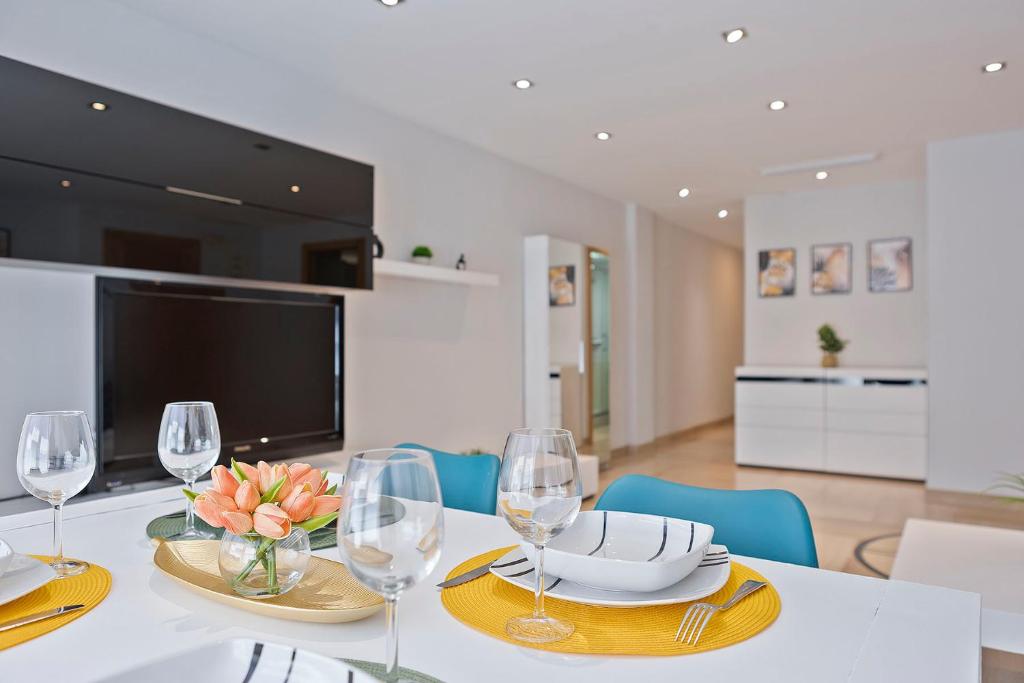 a dining room with a table with wine glasses at Cómodo y luminoso apto cerca de Playas y Valencia in Sueca