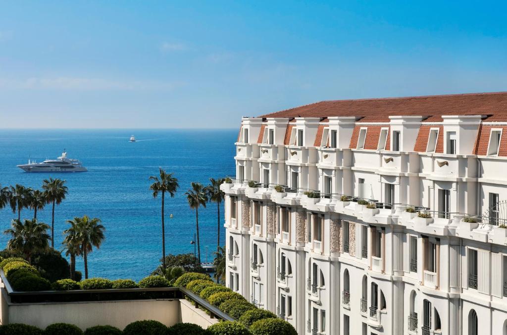 a large white building with a view of the ocean at Hôtel Barrière Le Gray d'Albion in Cannes