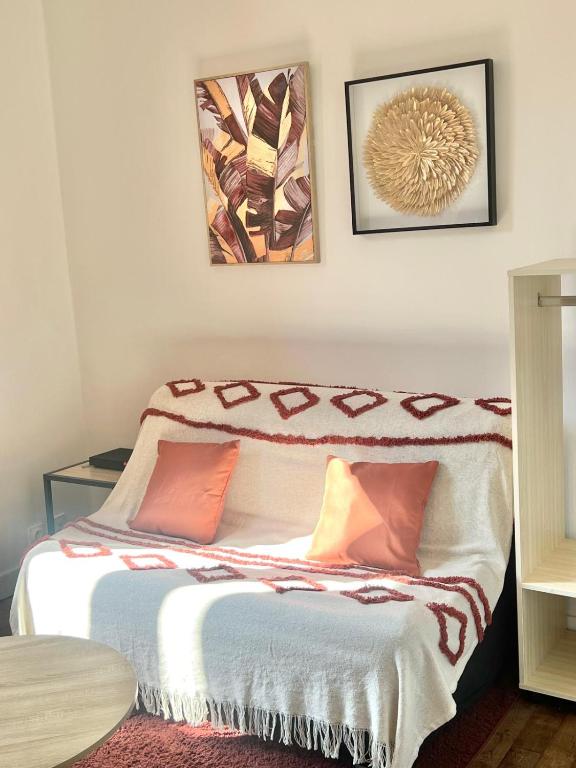 une chambre avec deux lits et deux tableaux au mur dans l'établissement Charmant Studio à Poitiers, à Poitiers