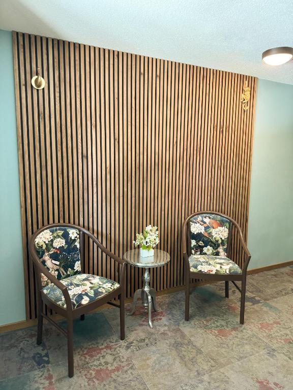 a room with two chairs and a table with flowers at Villa Fantasia Budget Boutique Hotel in Füssen