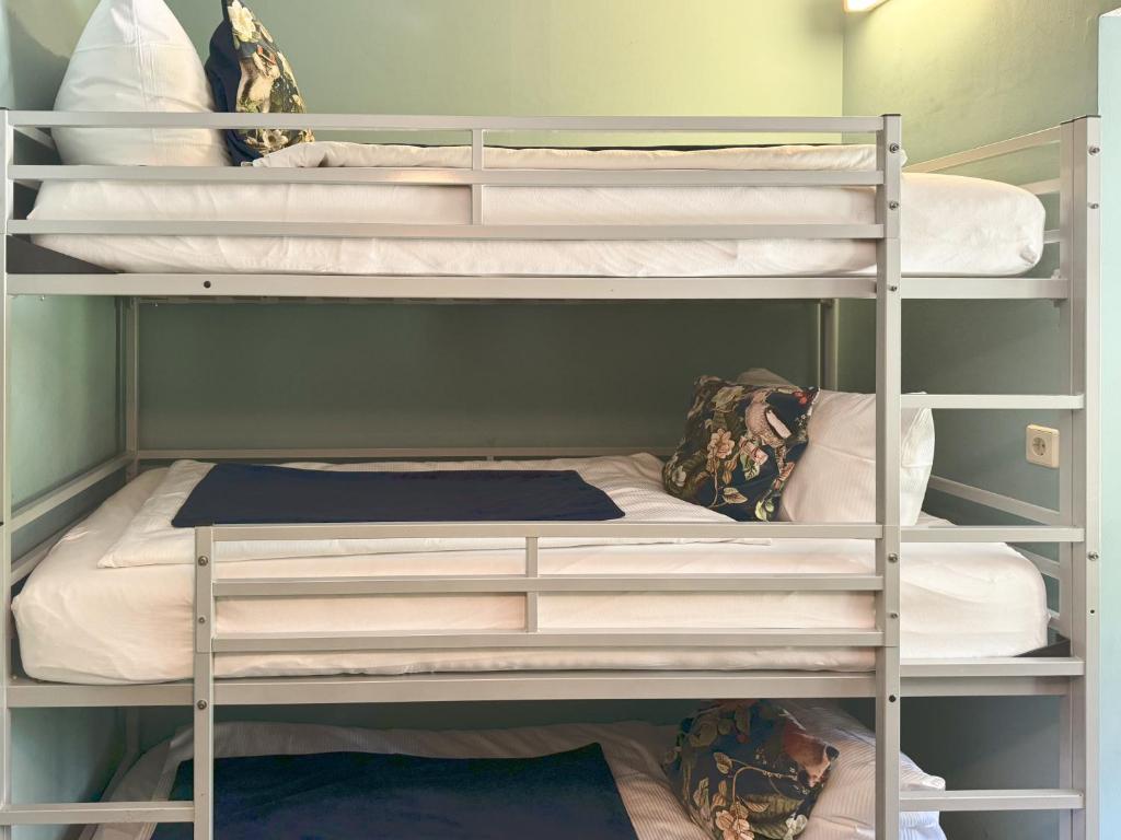 a bunk bed room with three bunk beds at Villa Fantasia Budget Boutique Hotel in Füssen