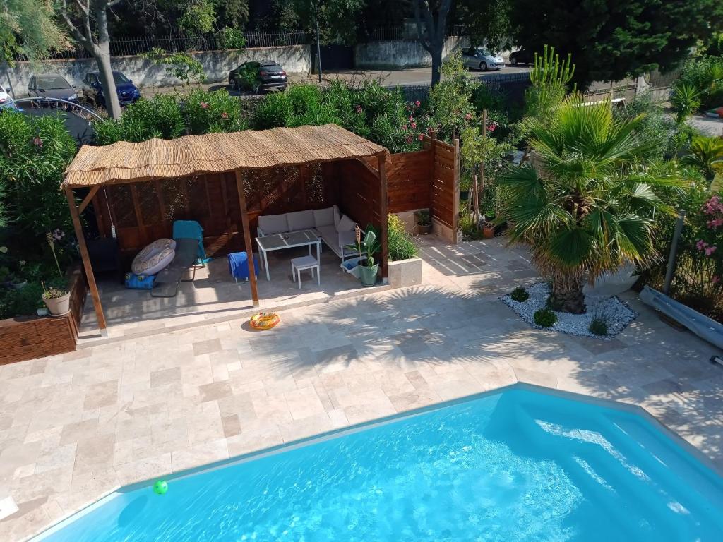 une cour arrière avec une piscine et un gazebo dans l'établissement La provençale, à Fontvieille