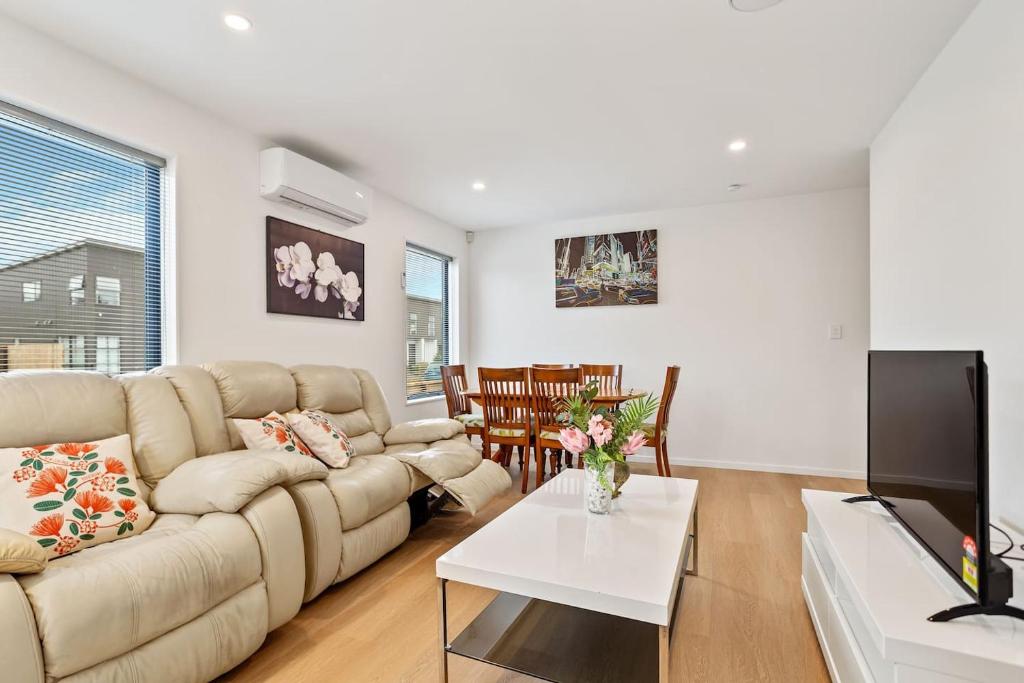 a living room with a couch and a table at Ventura Delight Townhouse with Parking and Patio in Auckland