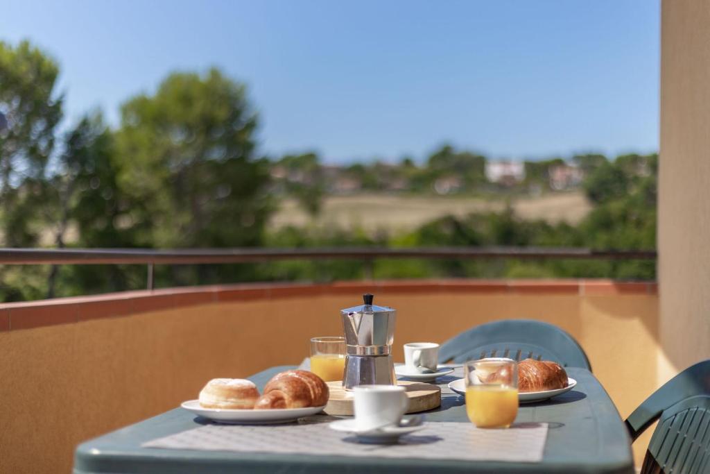 stół ze śniadaniem i sokiem pomarańczowym na balkonie w obiekcie Italian Experience-Numana Suite Apartment w mieście Numana