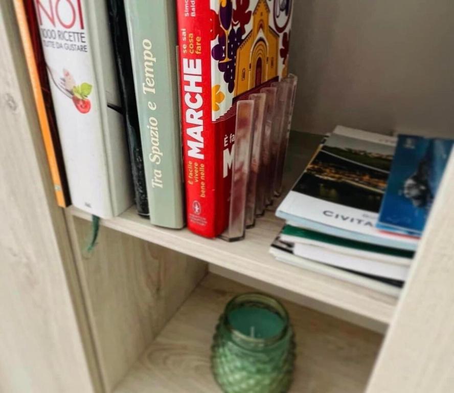 półka z książkami i wazonem w obiekcie Italian Experience-Numana Suite Apartment w mieście Numana