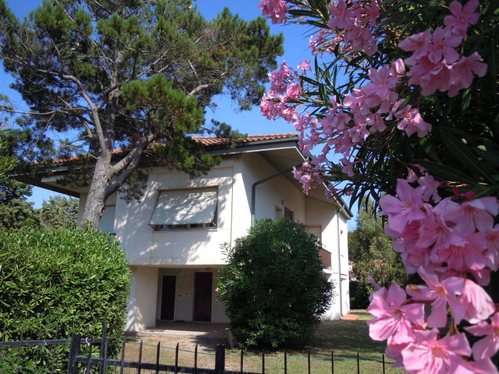 biały dom z różowymi kwiatami przed nim w obiekcie Italian Experience-Casa Argentario w mieście Giannella