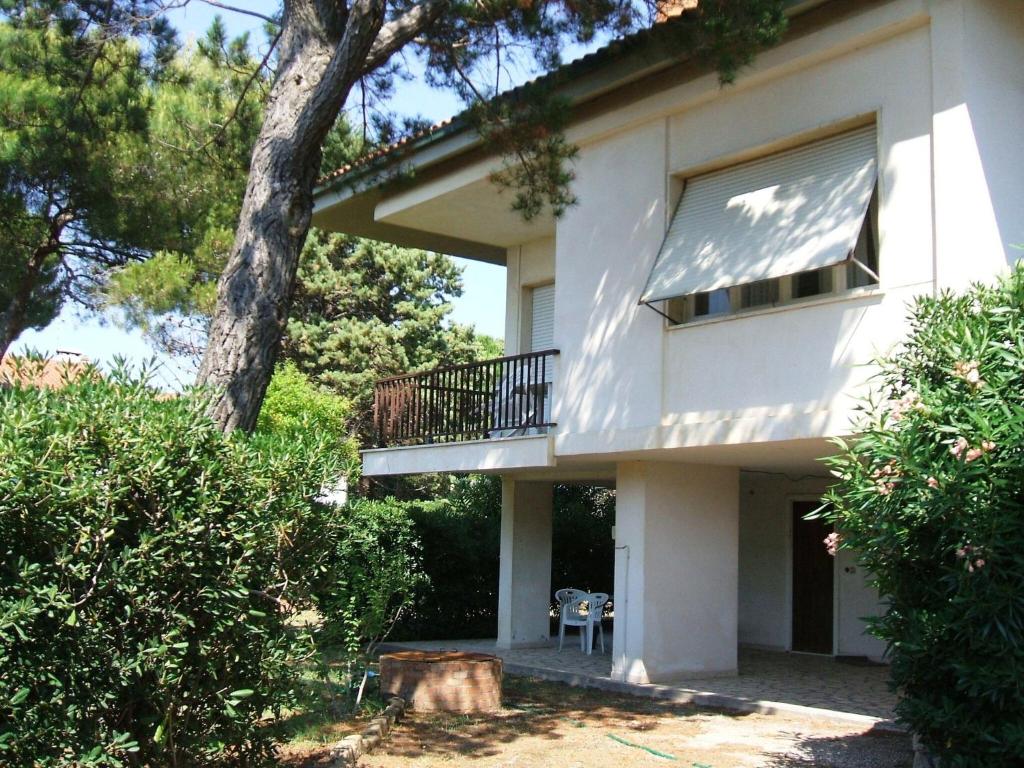 biały dom z balkonem i drzewem w obiekcie Italian Experience-Casa Argentario w mieście Giannella