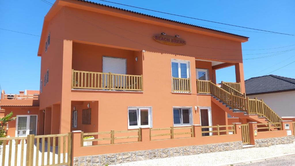 Casa grande de color naranja con balcón en Guesthouse Beach Break, en Peniche