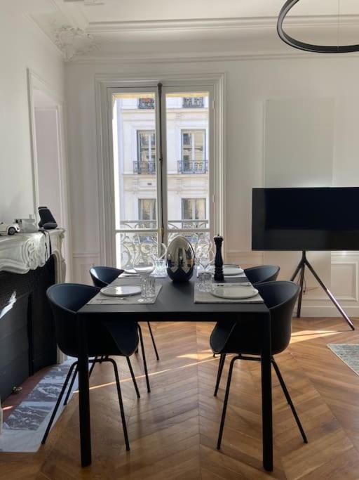 - un salon avec une table à manger et des chaises dans l'établissement Joyau au coeur du Marais - refait à neuf - luxueux, à Paris