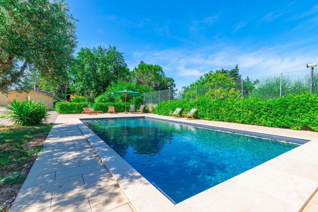 ein Swimmingpool mit blauem Wasser in einem Hof in der Unterkunft Italian Experience - Sunrise Hill Holiday Home in Urbisaglia