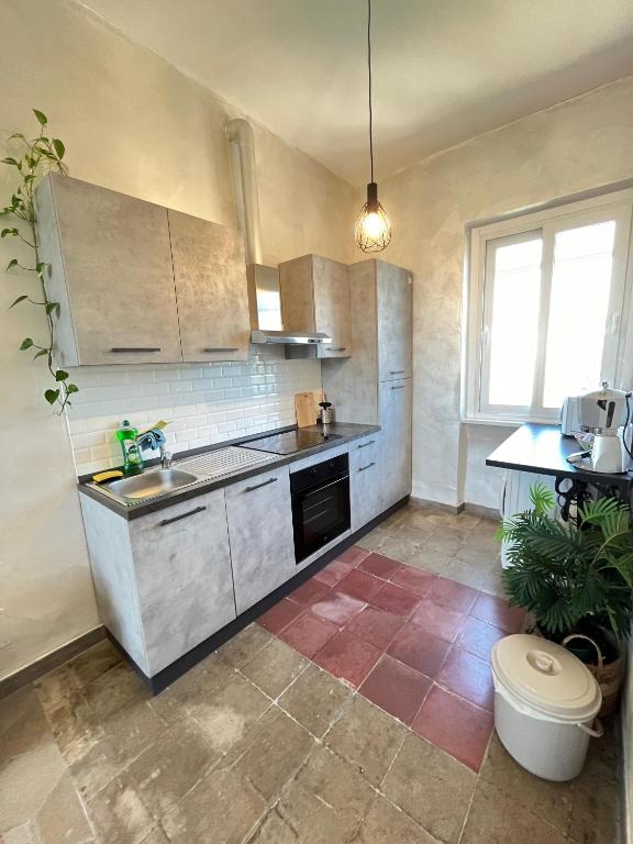 una cucina con lavandino e piano di lavoro di Il Nido apartment Roma, Attico ostiense a Roma