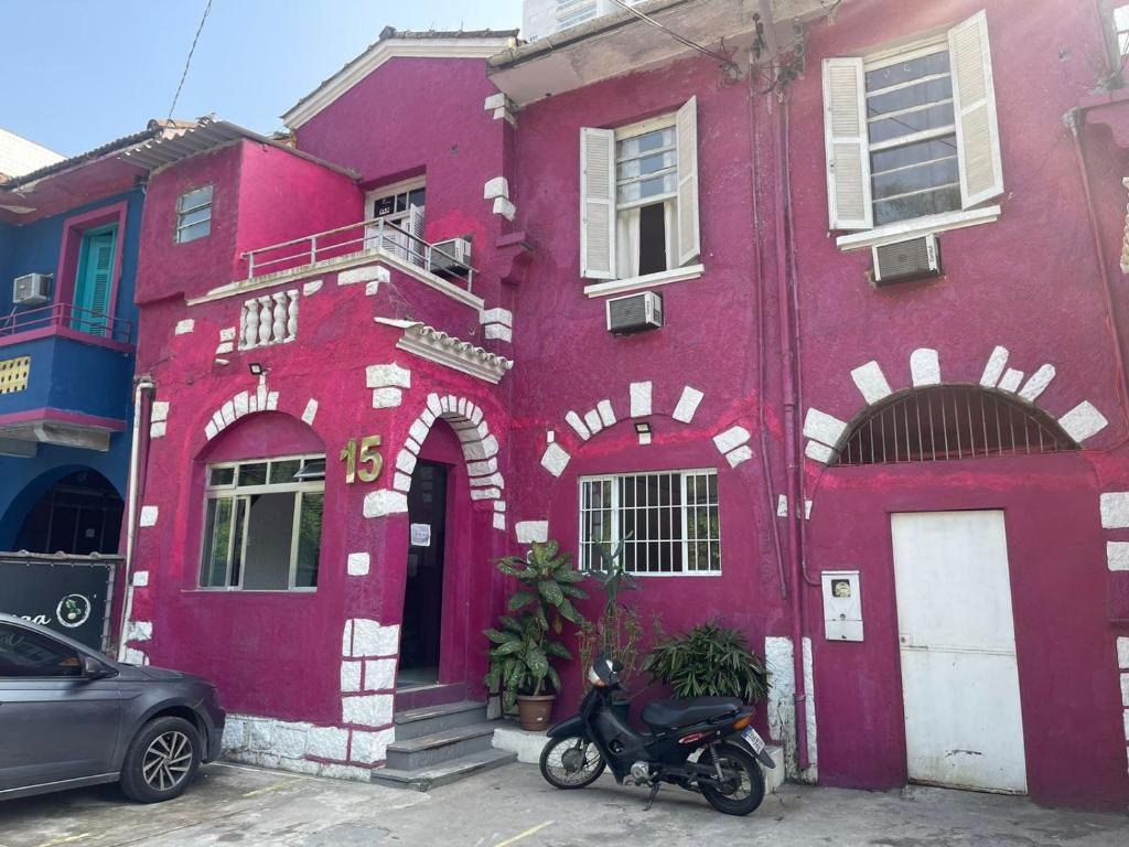 a purple building with a scooter parked in front of it at Pousada Vila Pitanga in Santos