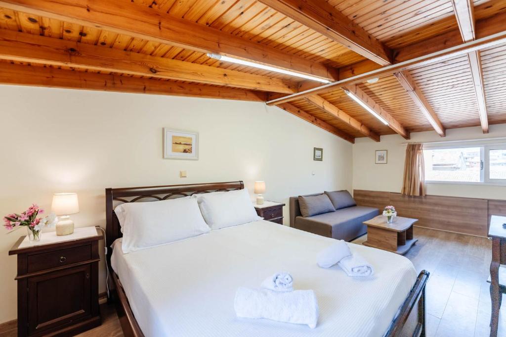 a bedroom with a large white bed and a chair at Liston Suites in Corfu Town