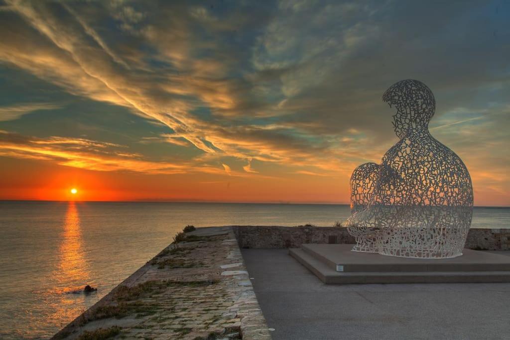 une sculpture d'un homme assis sur une jetée au coucher du soleil dans l'établissement 2 pièces dans la vieille ville, à Antibes