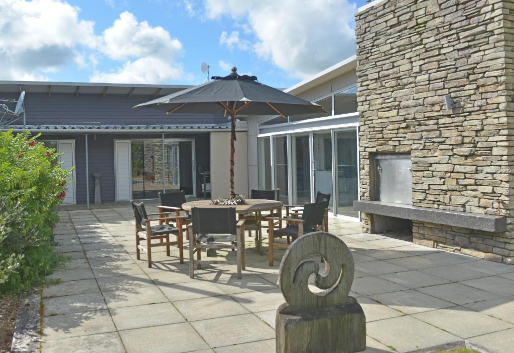 eine Terrasse mit einem Tisch und einem Sonnenschirm in der Unterkunft Platinum Lodge in Stratford