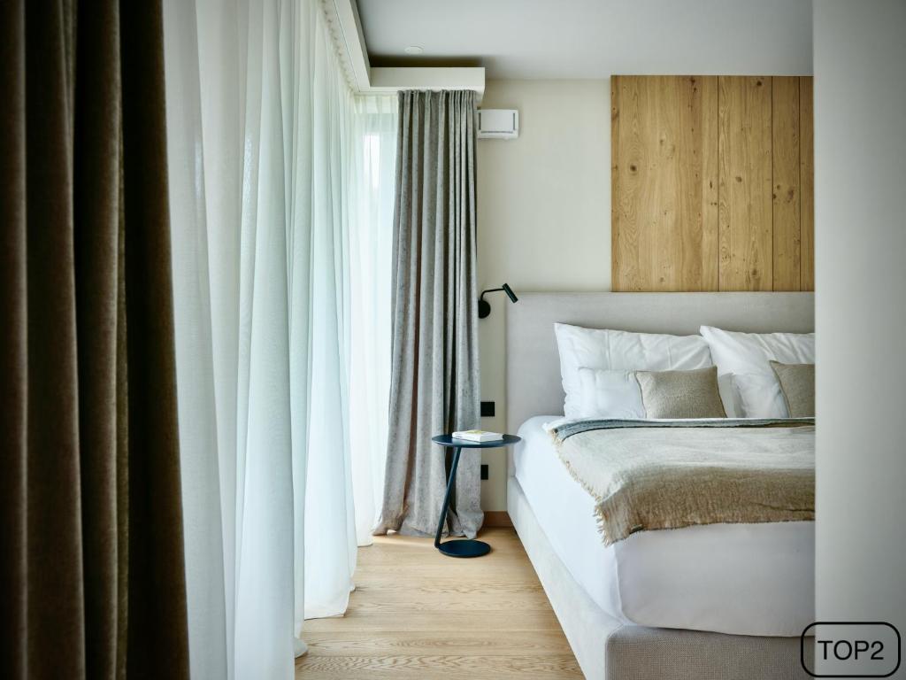 a bedroom with a white bed and a window at Haus am Lift - TOP2 - Summercard included - Ski-in Ski-out - 6P in Zell am See
