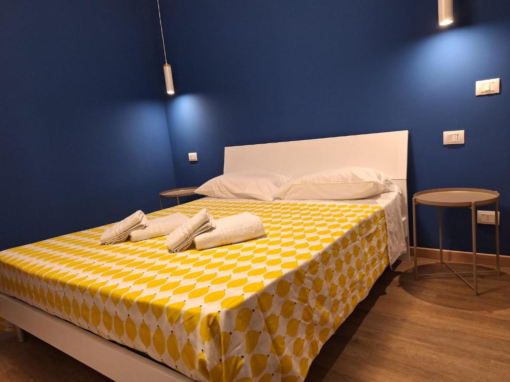 a bed with a yellow and white checkered blanket at B&B Onda Marina Villa Bellini Catania Centro in Catania