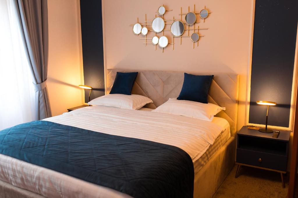 a bedroom with a bed with two pillows and a chandelier at Al Centro in Bucharest