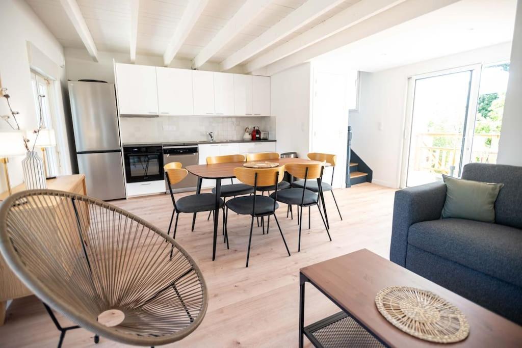 un salon avec une table et des chaises et une cuisine dans l'établissement KER PIRAH Appartement proche des plages centre carnac plage, à Carnac
