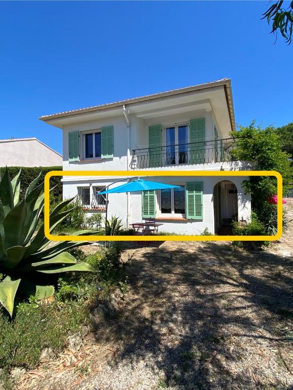une maison avec un cadre jaune devant elle dans l'établissement Chez Madou, T1 en bas de villa et rez de jardin à 900m de la mer et des commerces, à Fréjus