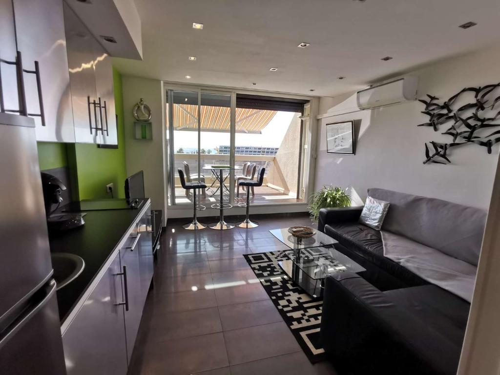 une cuisine et un salon avec un canapé et une table dans l'établissement Appartement Luxe - 4 personnes PETROUCHKA - Héliopolis J 41 -, au Cap d'Agde