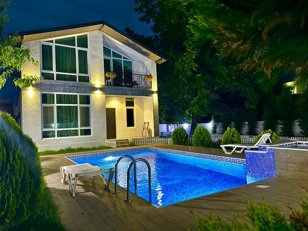 a swimming pool in front of a house at Qafqaz Resort Wonderland in Gabala