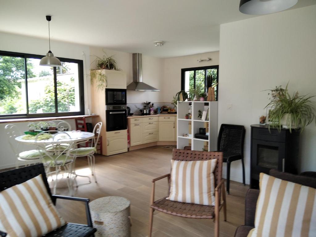 une cuisine et une salle à manger avec une table et des chaises dans l'établissement jolie maison à la campagne, à Rétaud