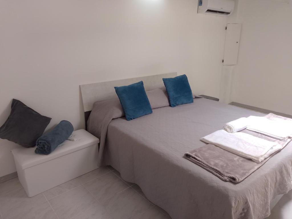 a small bedroom with a bed with blue pillows at Casa vacanze Eugenia in Ragusa
