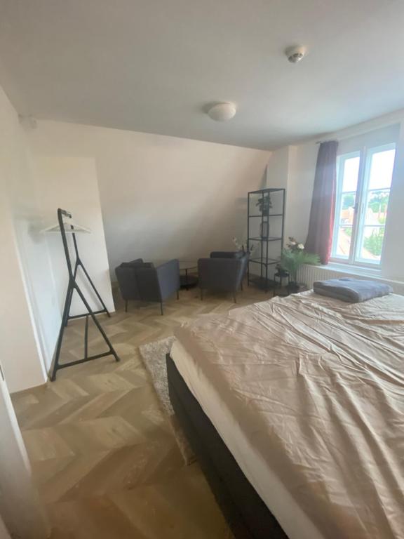 a bedroom with a bed and a room with chairs at Apartmán v centru Krumlova in Český Krumlov