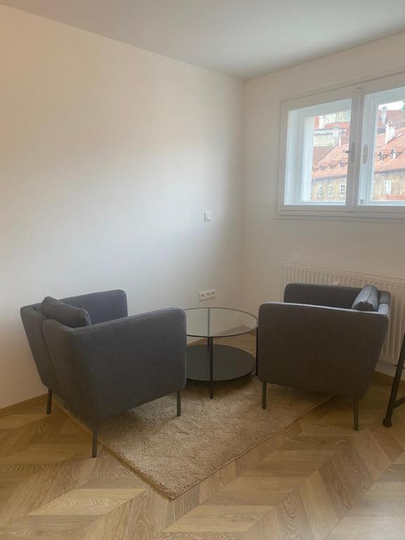 a living room with two couches and a glass table at Apartmán v centru Krumlova in Český Krumlov