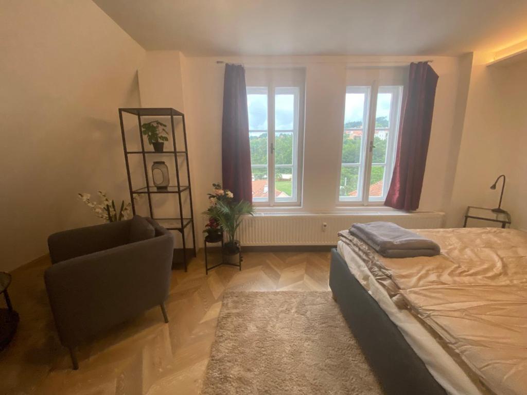 a bedroom with a bed and a chair and a window at Apartmán v centru Krumlova in Český Krumlov