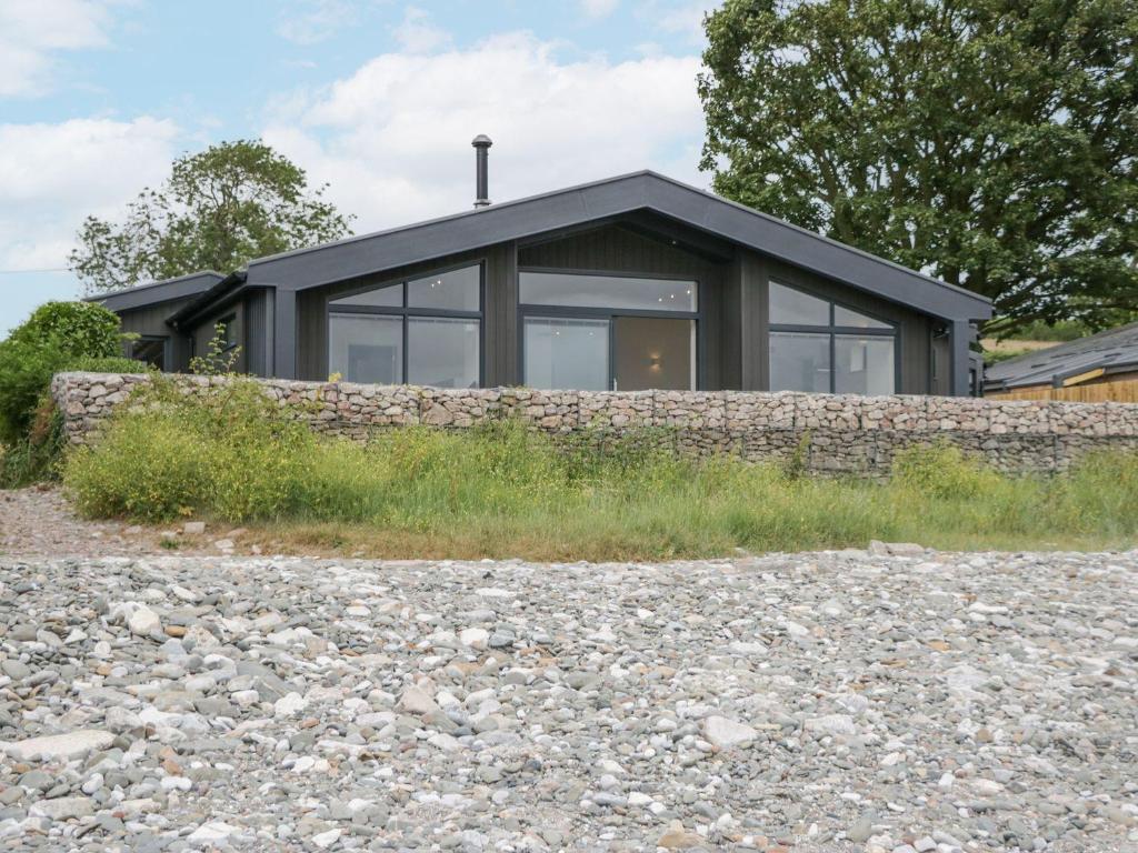 a house with a stone wall and a window at Driftwood Cottage in Ulverston