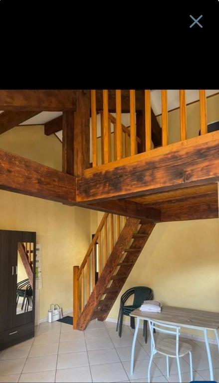 - un escalier en bois dans une chambre avec une table et des chaises dans l'établissement Escale à Aubenas, à Aubenas