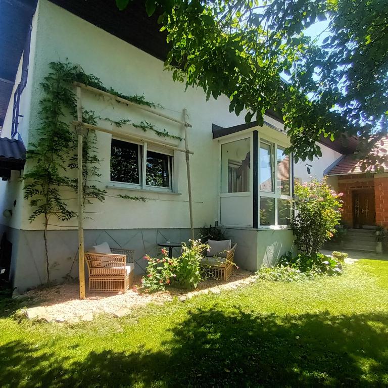 a white house with a window and a yard at The Cottage in Murska Sobota
