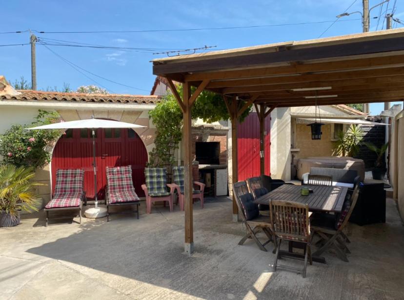 a patio with a table and chairs under a pavilion at APPARTEMENT TOUT CONFORT AVEC PARKING FERMÉ in Arles