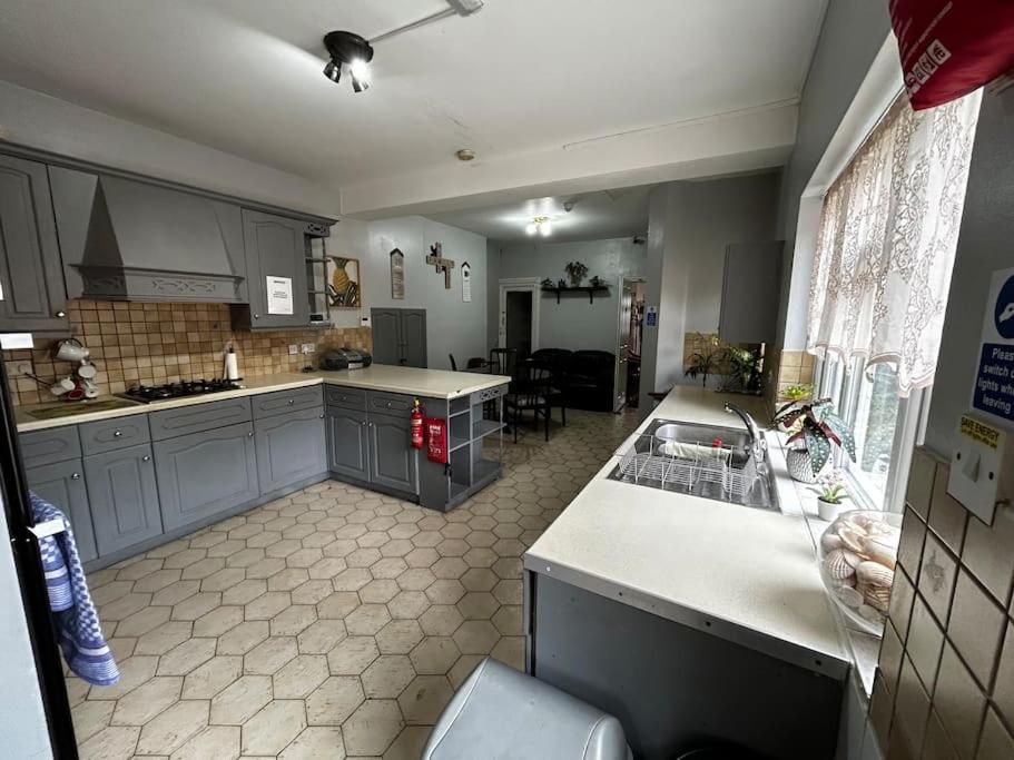 a kitchen with a sink and a counter top at Amazing 6 bedroom house with free parking on site. in Norbury