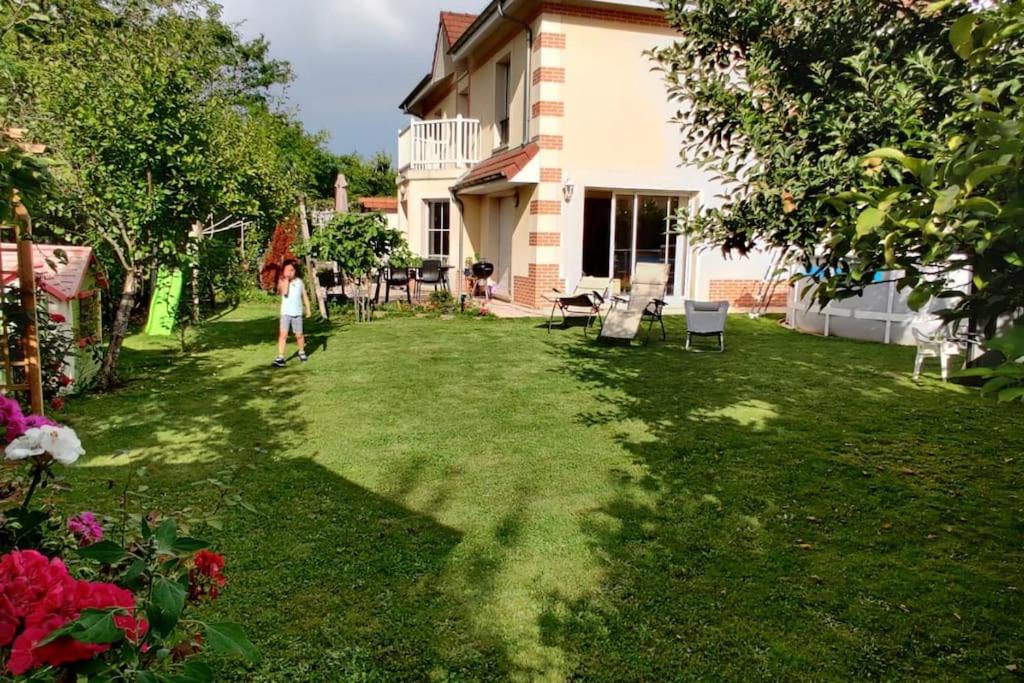 une femme debout dans la cour d'une maison dans l'établissement Proche Disneyland Paris, magnifique villa, à Bussy-Saint-Georges