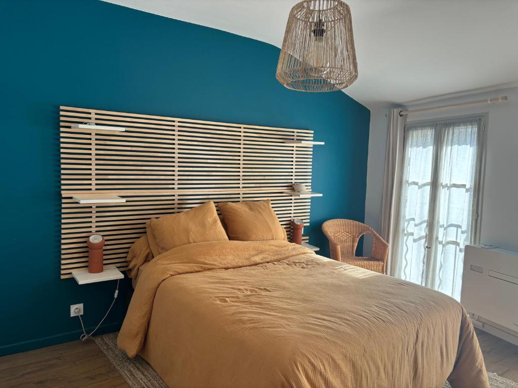 une chambre avec un grand lit avec un mur bleu dans l'établissement Appartement intra-muros Avignon, à Avignon