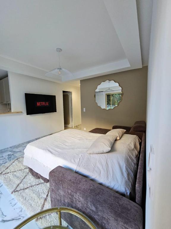 une chambre avec un lit et une télévision au mur dans l'établissement Charmant studio centre de Cannes, à Cannes