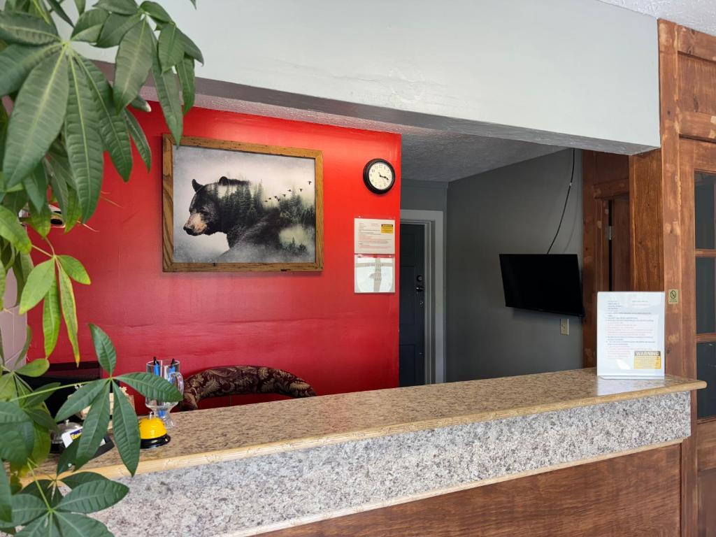Una pared roja con la imagen de un oso. en Economy Inn, en Crossville