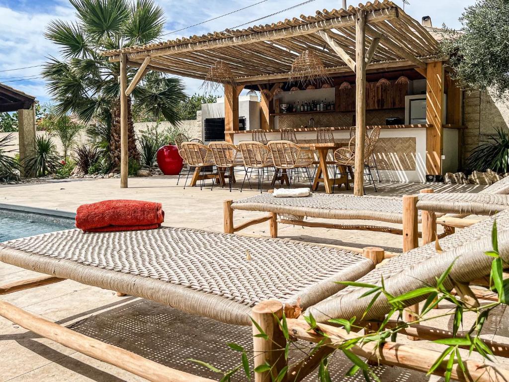 un patio avec tables et chaises à côté d'une piscine dans l'établissement Charmante villa avec piscine chauffée, proximité des plages, à Vias
