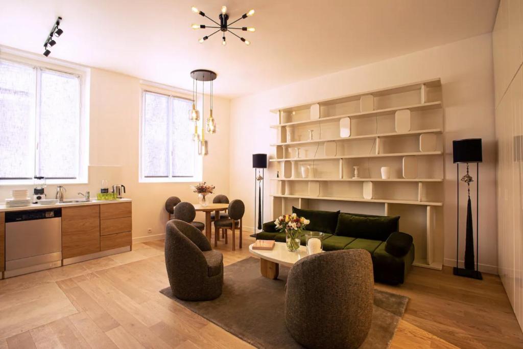 un salon avec un canapé, des chaises et une table dans l'établissement Luxueux Appartement - Centre de Paris, à Paris