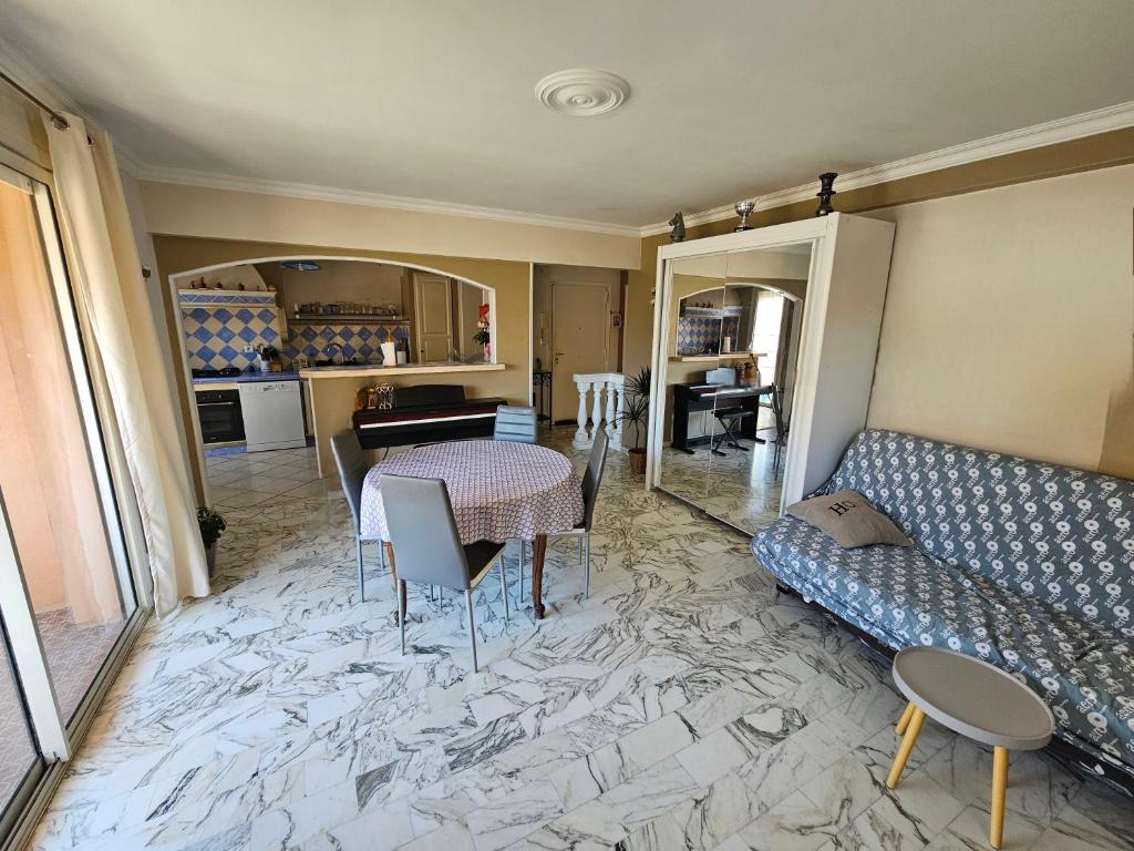 un salon avec une table et un canapé dans l'établissement au calme et 2 pas de la mer, à Nice