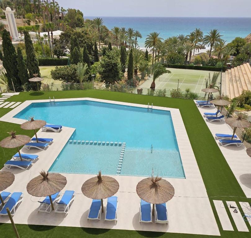 an overhead view of a swimming pool with chairs and umbrellas at Perfecto Apartamento para vacaciones frente al mar in Villajoyosa