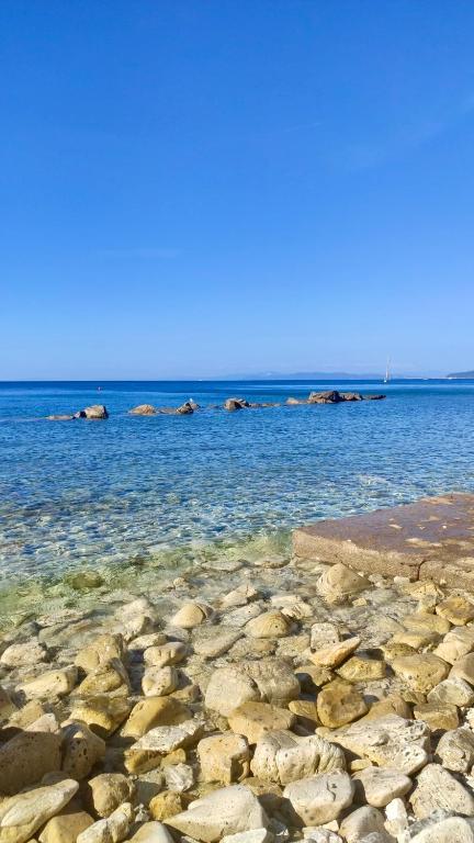 a large body of water with rocks in it at Podere Il Ritorno in Portoferraio