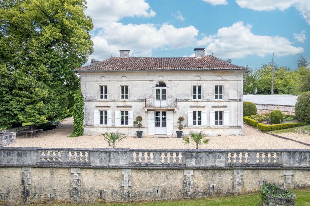 an old stone wall in front of a house at Domaine la Boissière in Grand Brassac