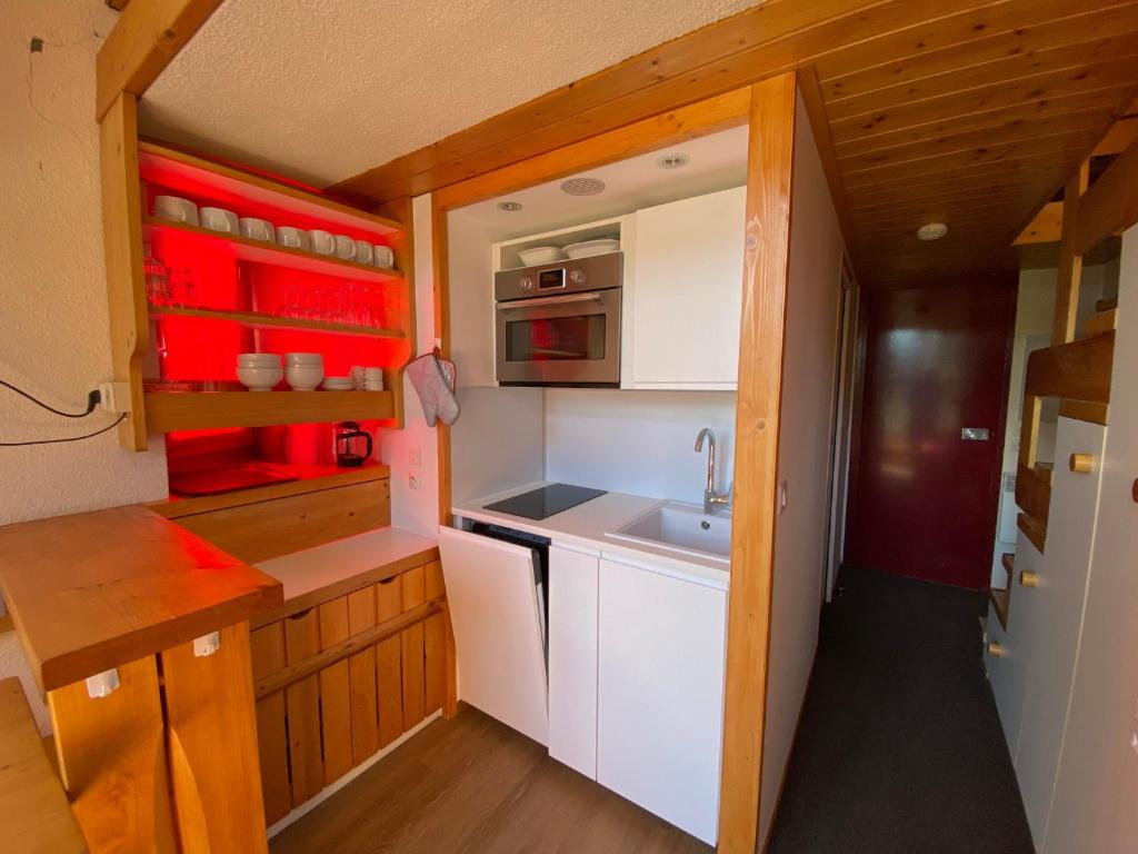 une petite cuisine avec des armoires blanches et un évier dans l'établissement Studio cosy · Ski aux pieds · Balcon · 4 pers - FR-1-346-459, à Arc 1800