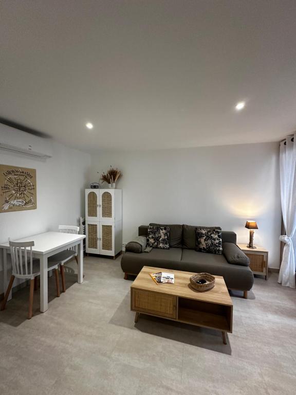 a living room with a couch and a table at Appartement "La Rose des Vents" in Saintes-Maries-de-la-Mer