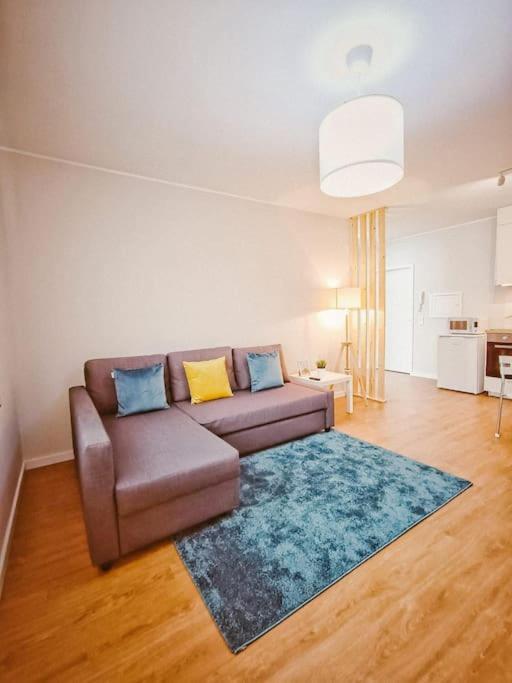 a living room with a brown couch and a blue rug at Alameda Apartments - Apartamento Moderno a 20 min do Porto in Trofa